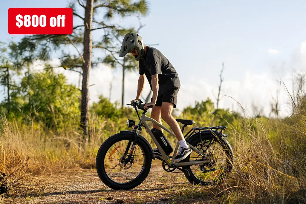 Person wearing helmet riding kingbull electric bicycle on dirt path in natural outdoor setting with $800 discount offer displayed