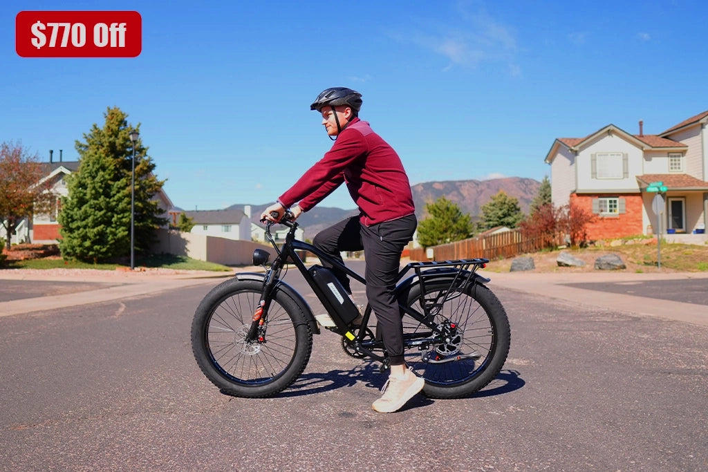 Man in red jacket riding black Kingbull Hunter 2.0 electric bike in suburban neighborhood - $770 off promotion