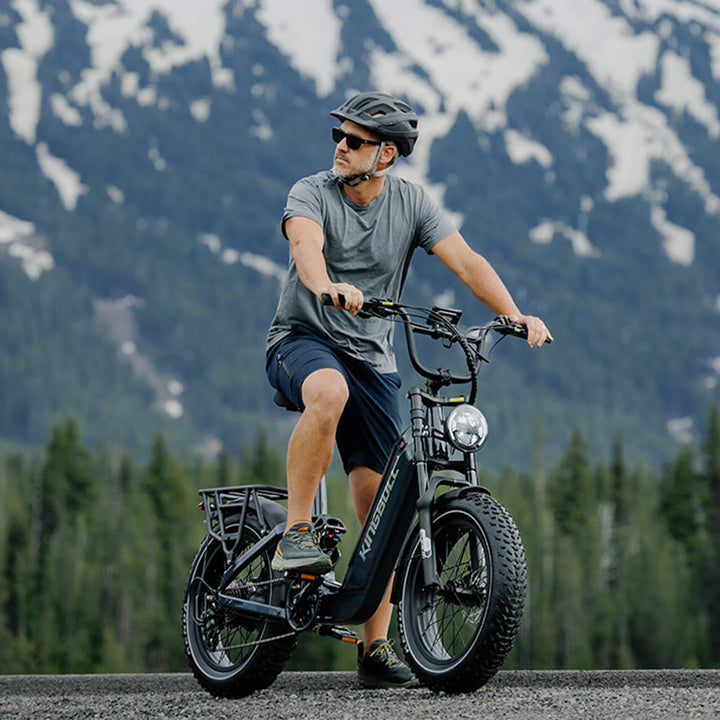 Cyclist riding black Kingbull Jumper Go electric bike with snow-capped mountains in background