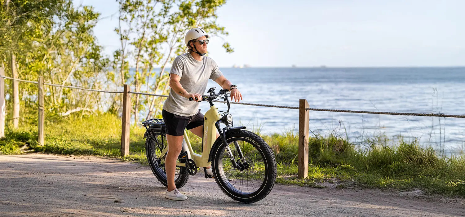 A man is riding his KINGBULL Trekker electric bike along a trail, enjoying the scenery.