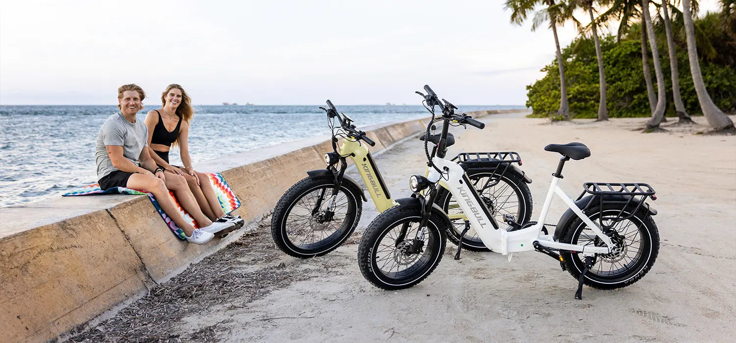 By the sea, a couple unwinds beside their KINGBULL e-bikes, soaking in the view and the moment.