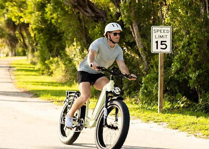 Man riding KINGBULL Trekker e-bike on a sunny tree-lined path, showcasing its Samsung 48V 960Wh battery and up to 80-mile range.