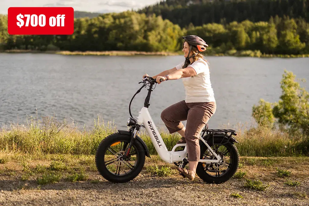 Woman riding a white kingbull folding electric bike with $700 discount written on the upper left corner