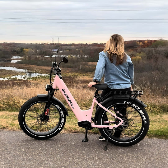 A pink Kingbull electric bike is parked in the trail.