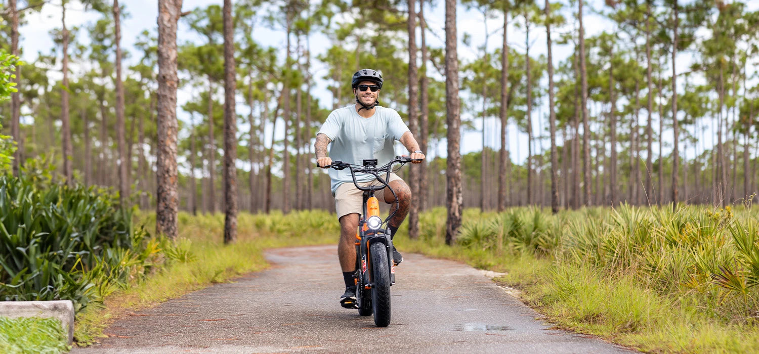 A man rides a Kingbull Voyager 2.0 dual-electric cargo e-bike along a trail.