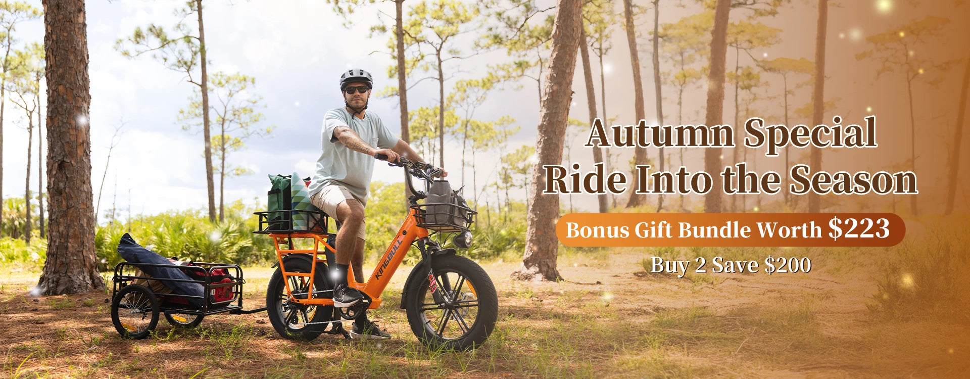 Autumn Special promotion banner showing a cyclist with helmet riding the Orange Kingbull Voyager2.0 electric bike through a sunny forest with a trailer attached, featuring text 'Ride Into the Season' with bonus gift bundle worth $223 and Buy 2 Save $200 offer